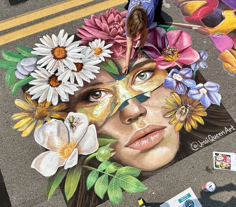 Street chalk portrait of a woman half hidden behind white daisies and wildflowers