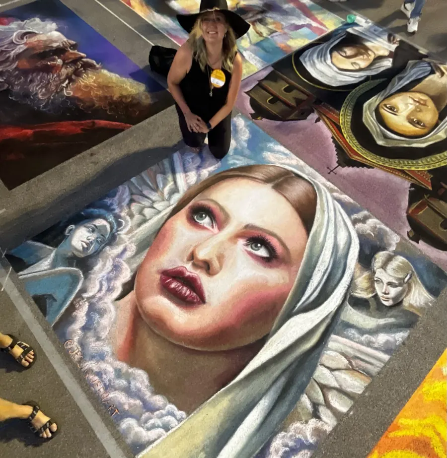 Jessi standing above a large chalk reproduction of a classical painting of a veiled woman and cherubs