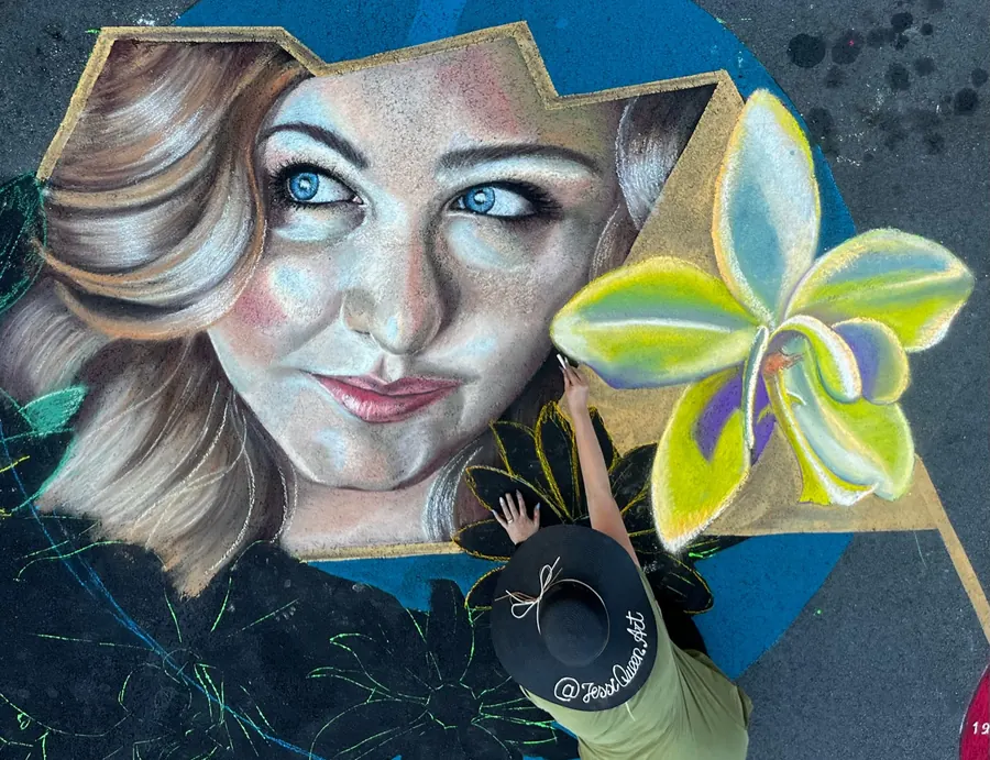 Chalk portrait of a blonde woman beside a bright yellow orchid