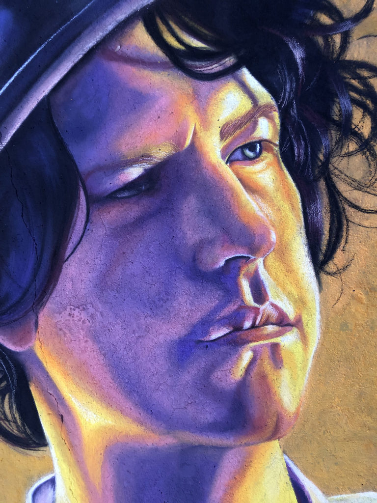 Close-up of the chalk portrait's face in violet and golden light