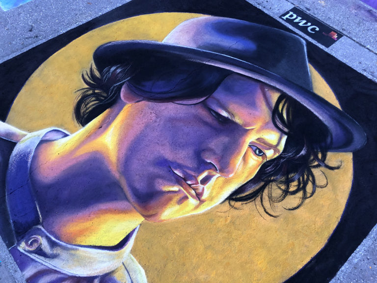 The chalk portrait of a young man in a hat against a golden circle, at an angle