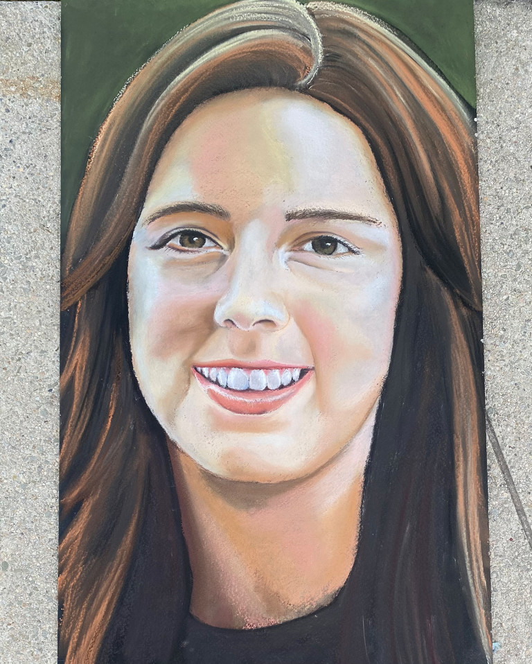 Chalk memorial portrait of a smiling young woman with long brown hair on the Flight 93 memorial walkway