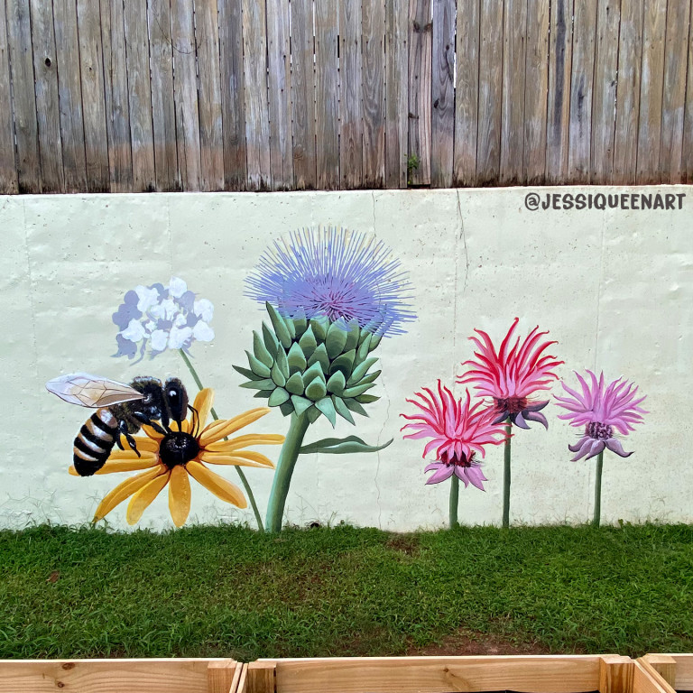 Painted garden mural of a bee on a black-eyed Susan beside thistles and pink blooms
