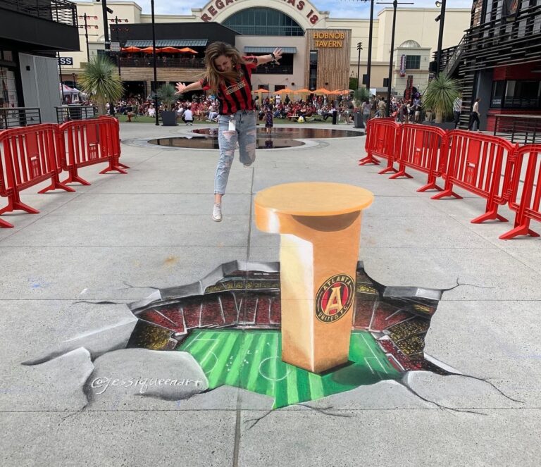 Jessi leaping over a 3D chalk Atlanta United pillar rising from a hole that opens onto the stadium field