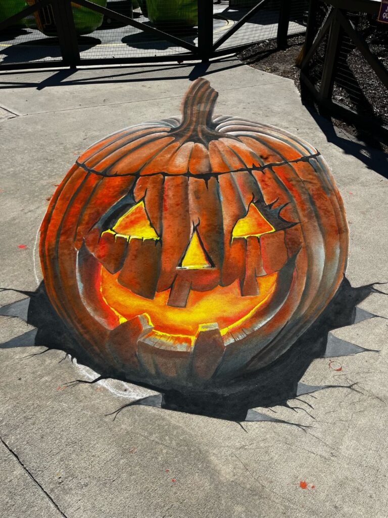 3D chalk jack-o'-lantern glowing as it bursts up through cracked pavement
