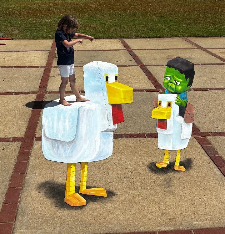 Child standing on a giant 3D chalk blocky white chicken beside a smaller chicken ridden by a green zombie