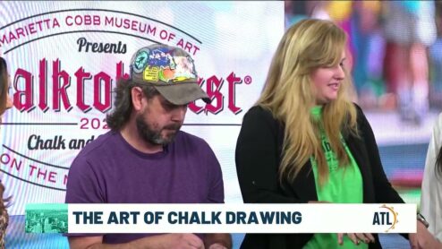 Still from the ATL Live segment The Art of Chalk Drawing: Zach Herndon and Jessi in the studio in front of the Chalktoberfest backdrop