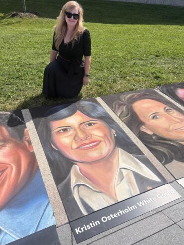 Jessi kneeling on the grass beside her chalk portrait of Kristin Osterholm White Gould