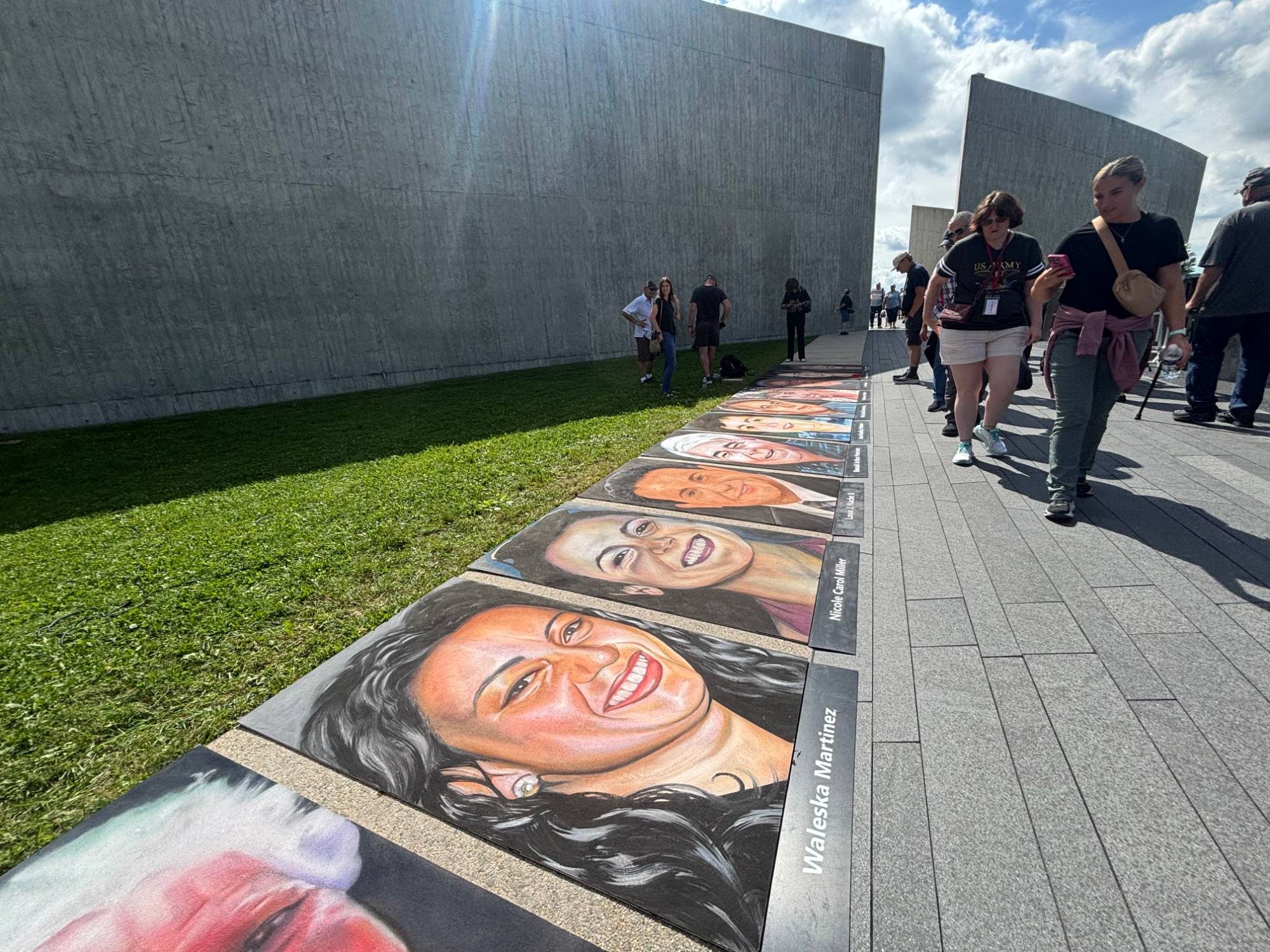Visitors passing the row of chalk portraits, with Waleska Martinez and Nicole Carol Miller in front