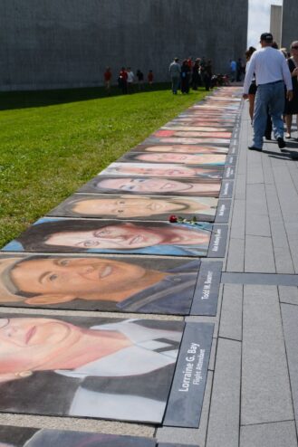 Chalk portraits of the passengers and crew lined up along the walkway, each labeled with a name, with a single red rose laid on one