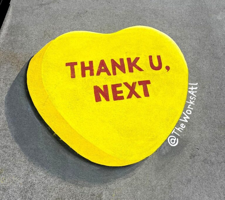 3D chalk yellow candy heart reading Thank U, Next on a sidewalk